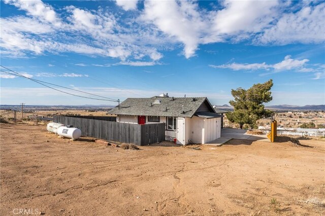 exterior space featuring roof with shingles and fence