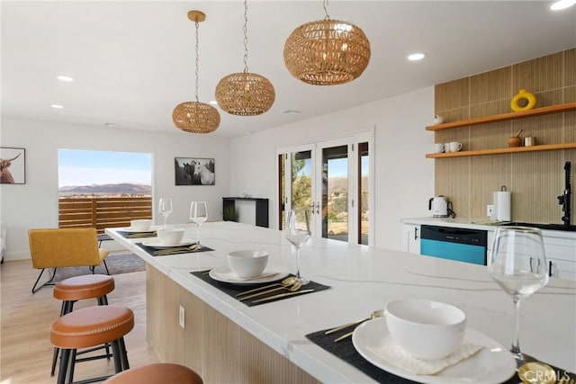 kitchen with plenty of natural light, light wood-type flooring, dishwasher, and a sink