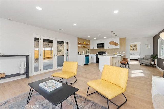 living room featuring recessed lighting, french doors, and light wood finished floors