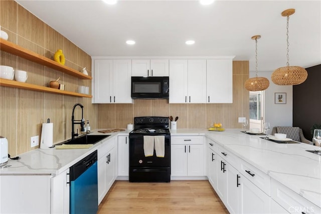 kitchen featuring light wood-style floors, white cabinets, a sink, and black appliances