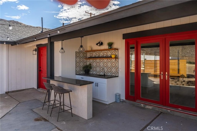 view of patio / terrace with french doors, a sink, and outdoor dry bar