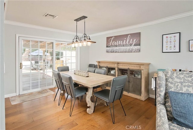 dining area featuring ornamental molding, visible vents, baseboards, and wood finished floors