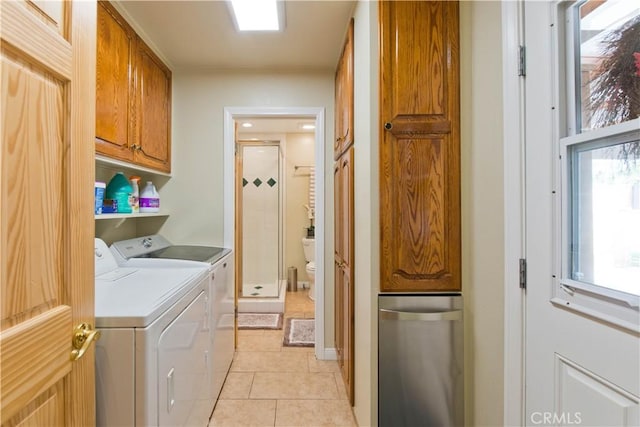 washroom with light tile patterned floors, independent washer and dryer, and cabinet space