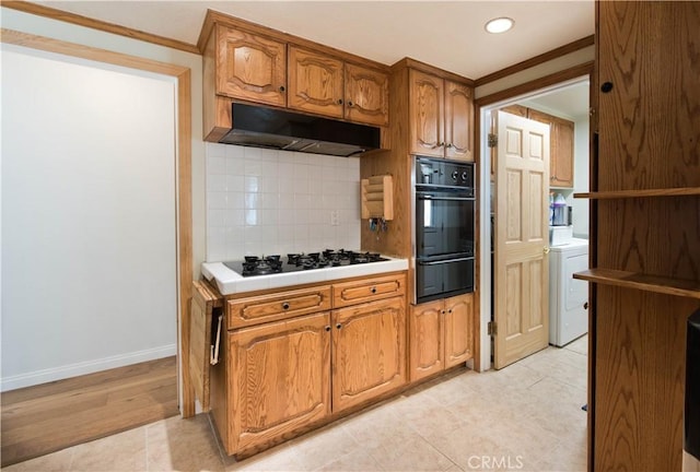 kitchen with brown cabinetry, light countertops, under cabinet range hood, gas cooktop, and a warming drawer