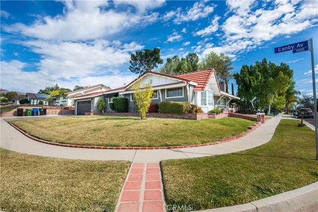 view of side of property featuring a garage, a tile roof, and a lawn