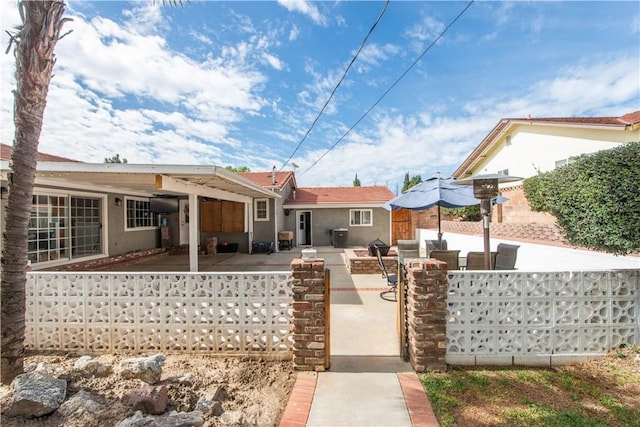 back of property featuring fence private yard, a patio area, and stucco siding