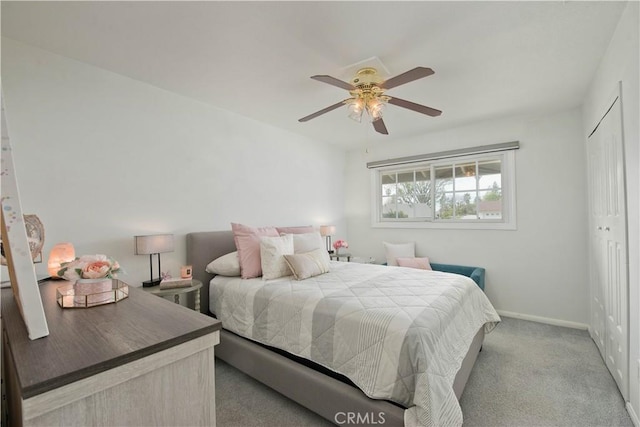 bedroom featuring a closet, light carpet, ceiling fan, and baseboards