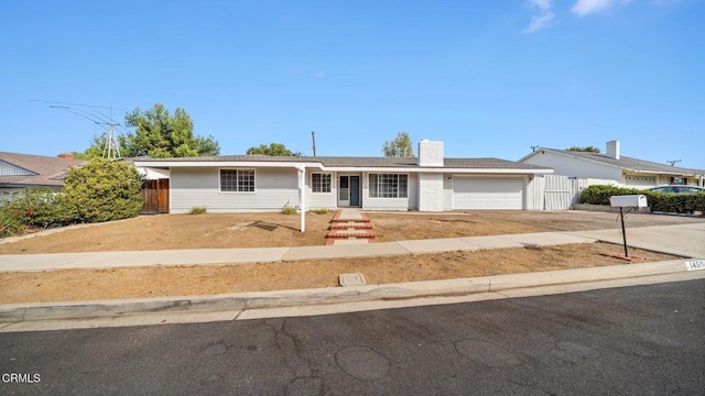 single story home with driveway, an attached garage, a chimney, and fence