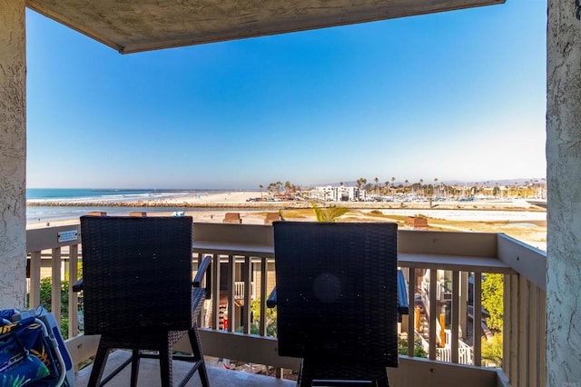 balcony with grilling area, a beach view, and a water view