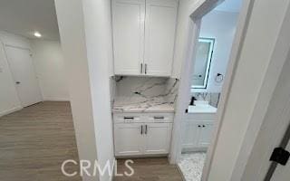 interior space with light wood-style flooring and backsplash