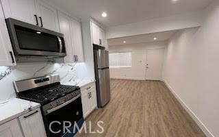 kitchen with appliances with stainless steel finishes, white cabinets, and light countertops