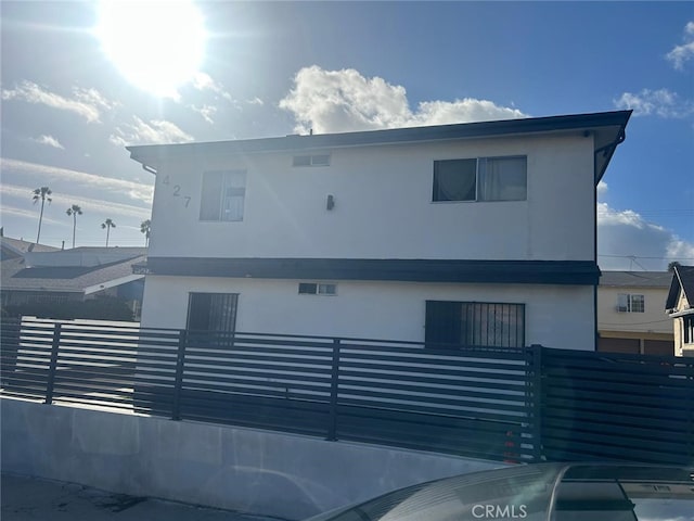 view of front of property featuring fence and stucco siding