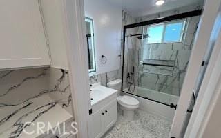 full bath with toilet, combined bath / shower with glass door, and vanity