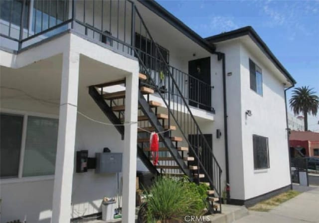 view of home's exterior with stairs and stucco siding