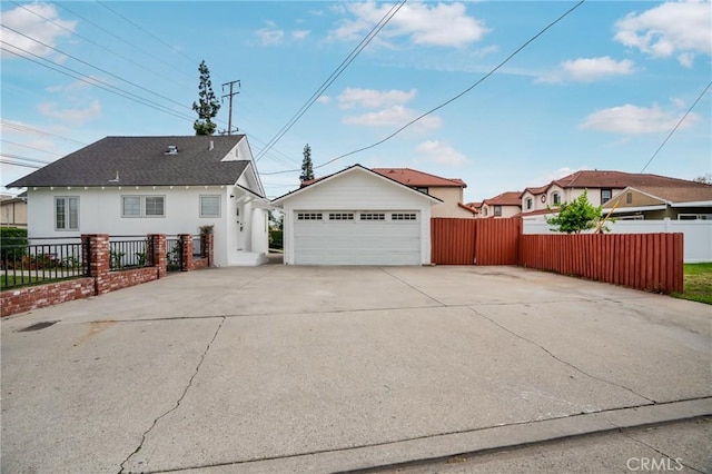 exterior space featuring stucco siding, fence, and a detached garage