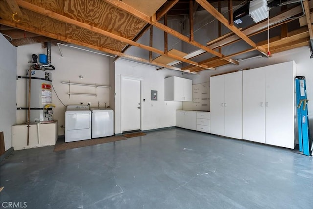 garage featuring strapped water heater and washer and dryer