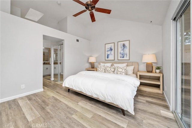 bedroom featuring ceiling fan, ensuite bath, high vaulted ceiling, light wood-type flooring, and baseboards