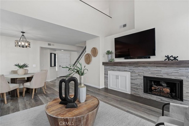 living room with visible vents, a fireplace, and wood finished floors