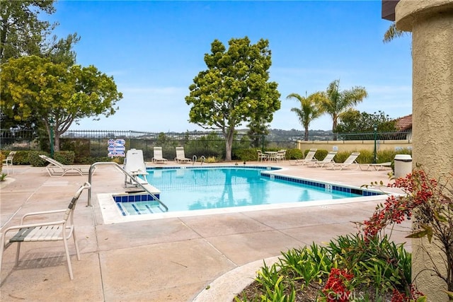 pool with a patio and fence