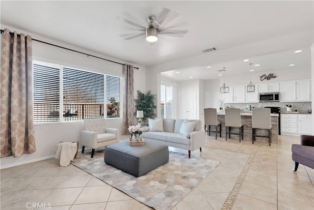 living room with light tile patterned floors, recessed lighting, visible vents, and baseboards