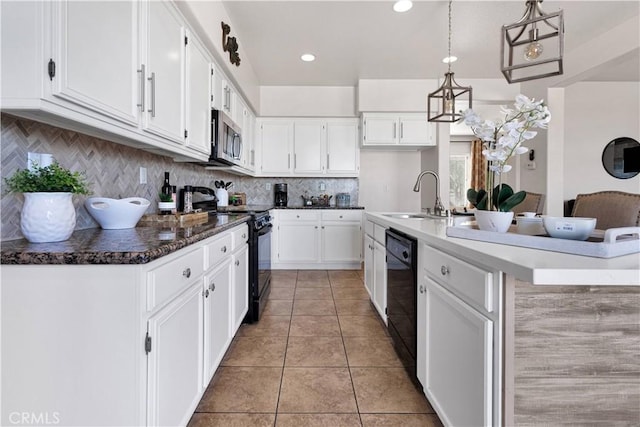 kitchen featuring tasteful backsplash, hanging light fixtures, black appliances, white cabinetry, and a sink