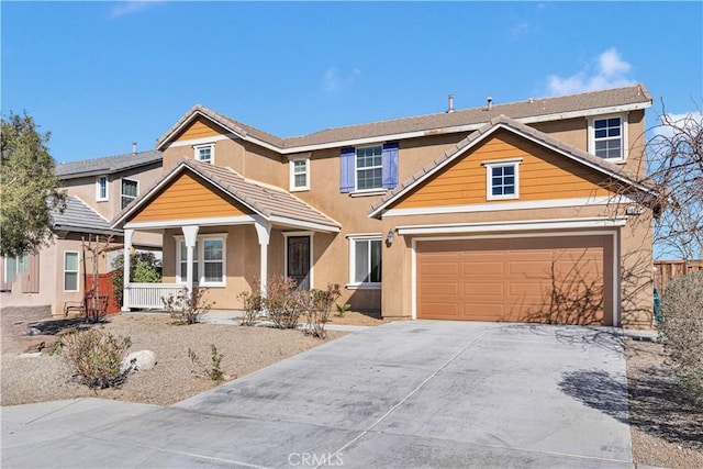 view of front facade with driveway, a porch, a tiled roof, and stucco siding