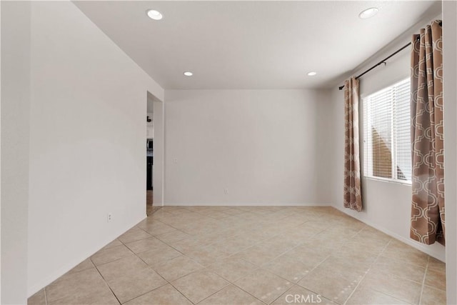 spare room featuring recessed lighting, tile patterned flooring, and baseboards