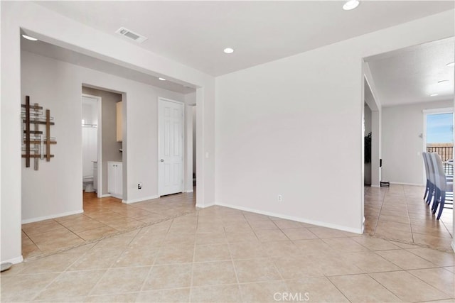 empty room with light tile patterned floors, baseboards, visible vents, and recessed lighting