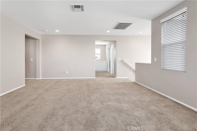 unfurnished room featuring carpet floors, baseboards, visible vents, and recessed lighting