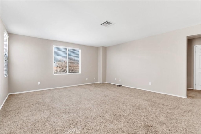 carpeted empty room featuring visible vents and baseboards