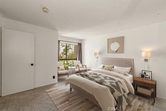 bedroom featuring light carpet and a textured ceiling