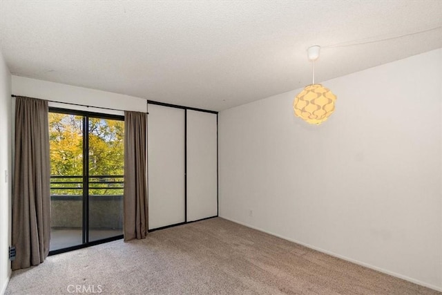 unfurnished room featuring light carpet and a textured ceiling