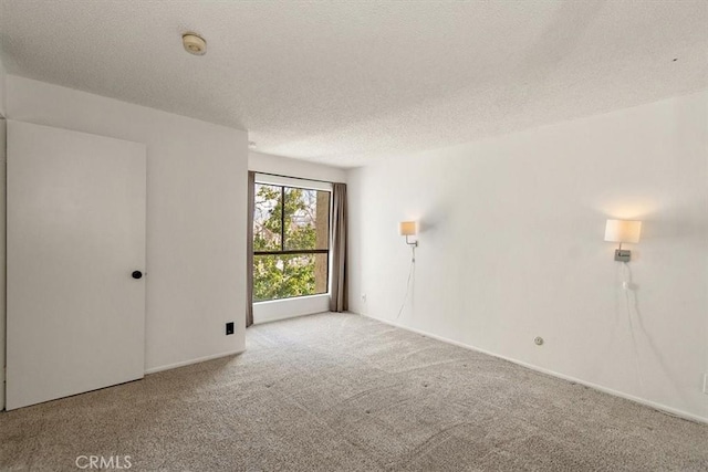 empty room featuring light carpet and a textured ceiling