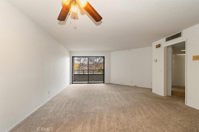 unfurnished room featuring ceiling fan, visible vents, a textured ceiling, and light colored carpet