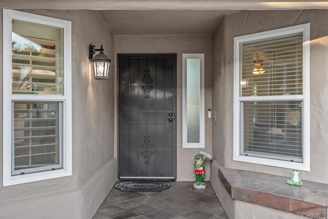 doorway to property featuring stucco siding