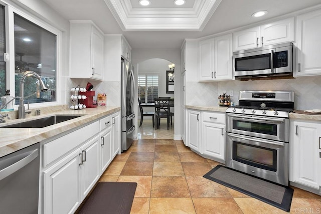 kitchen featuring white cabinets, arched walkways, and stainless steel appliances