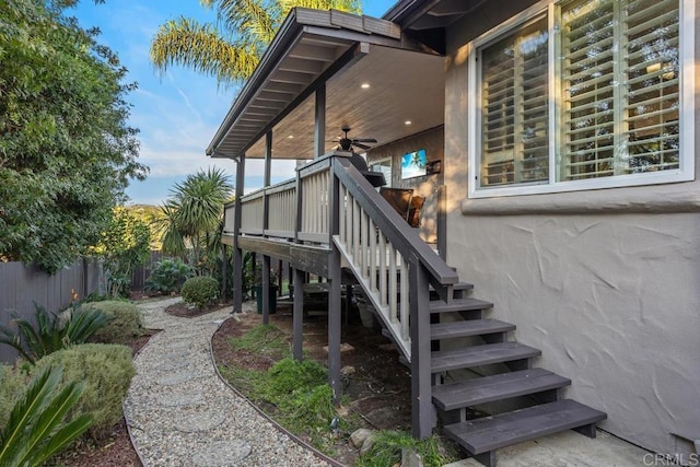 exterior space with fence and a ceiling fan