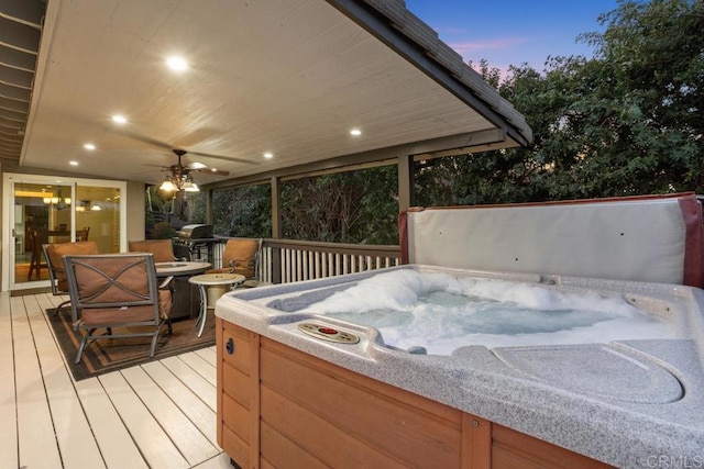 wooden deck with a hot tub and a ceiling fan