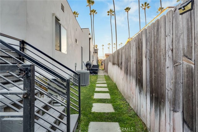 view of yard with central AC unit and fence