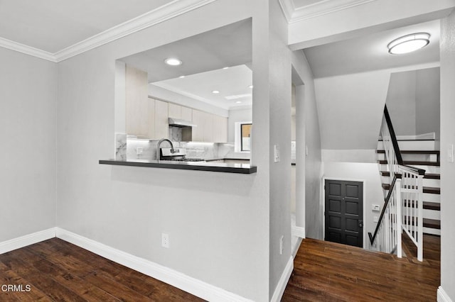 kitchen with dark countertops, dark wood finished floors, white cabinetry, and under cabinet range hood