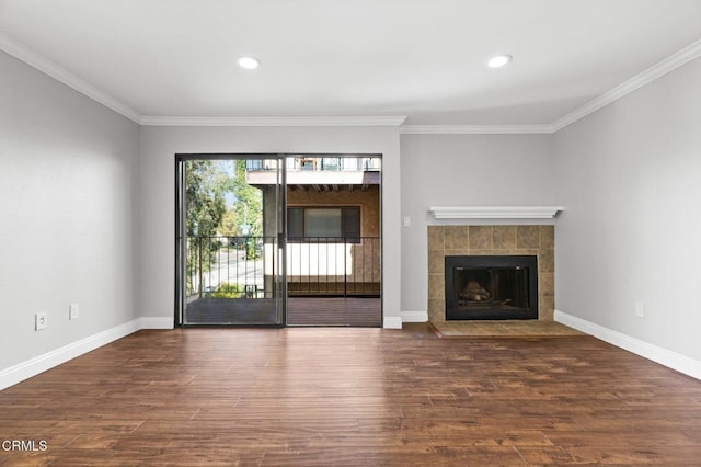 unfurnished living room featuring baseboards, ornamental molding, dark wood-style flooring, and a tile fireplace