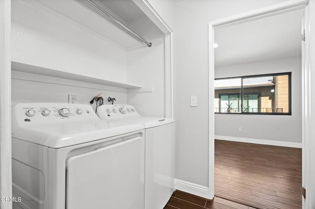 laundry area featuring laundry area, baseboards, separate washer and dryer, and dark wood-style flooring