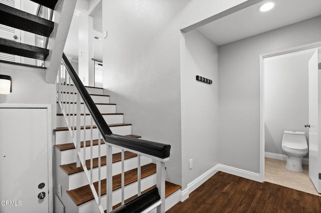 stairway featuring baseboards and wood finished floors