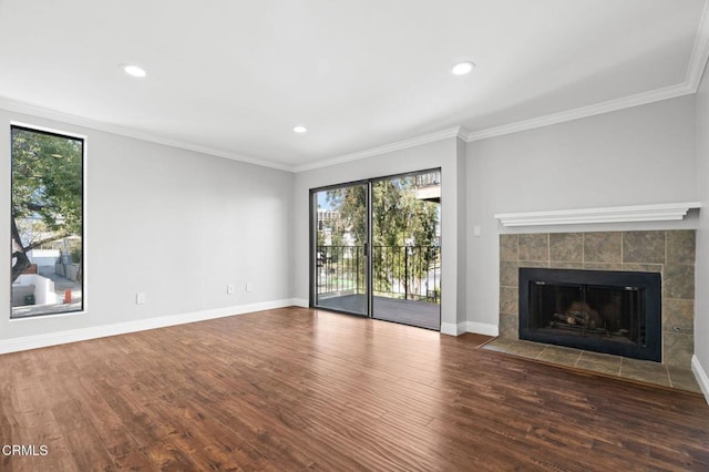 unfurnished living room with ornamental molding, a fireplace, dark wood finished floors, and a healthy amount of sunlight