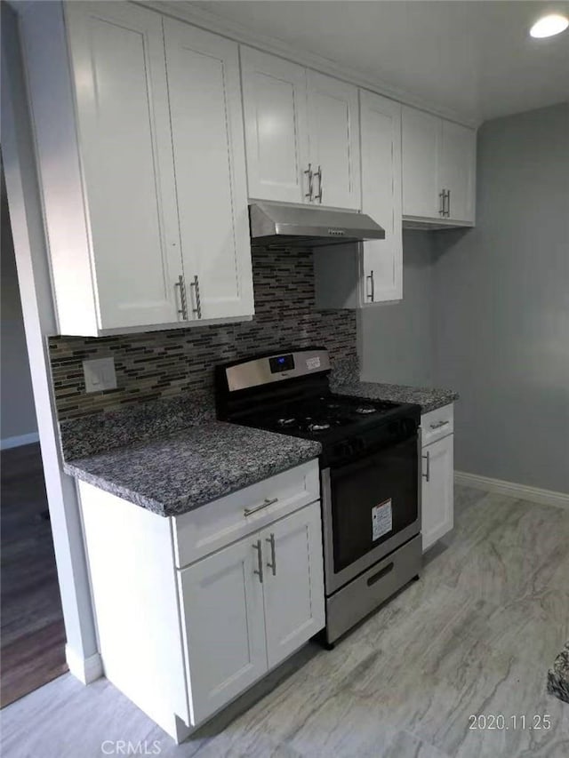 kitchen featuring white cabinets, stainless steel gas stove, and under cabinet range hood