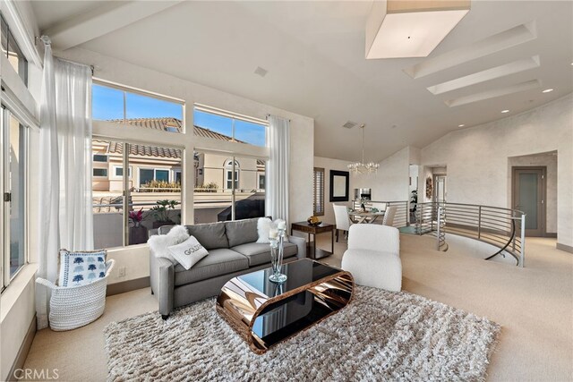 living room with light carpet, high vaulted ceiling, and a notable chandelier