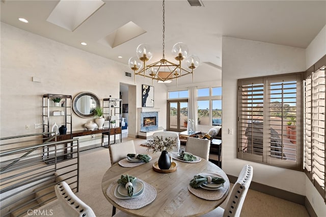 carpeted dining area featuring recessed lighting, a notable chandelier, a high ceiling, baseboards, and a lit fireplace