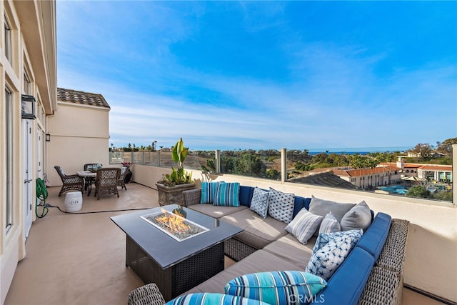 view of patio with outdoor dining area and an outdoor living space with a fire pit