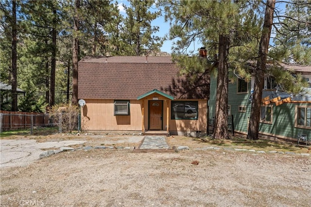 5768 Heath Creek Dr, Wrightwood, CA 92397 - view of front facade featuring a chimney, a shingled roof, and fence
