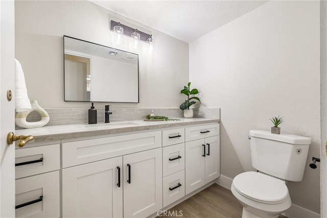 232 Kavenish Dr W, Rancho Mirage, CA 92270 - bathroom with baseboards, toilet, vanity, and wood finished floors
